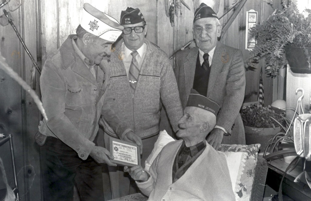 Photograph: Lawrence Nyland, Commander of VFW Post #1724 greets Sam Iorio, Ben Gorcyca and World War I veteran Stewart Swan in December 1988. (Lee Vold Collection)